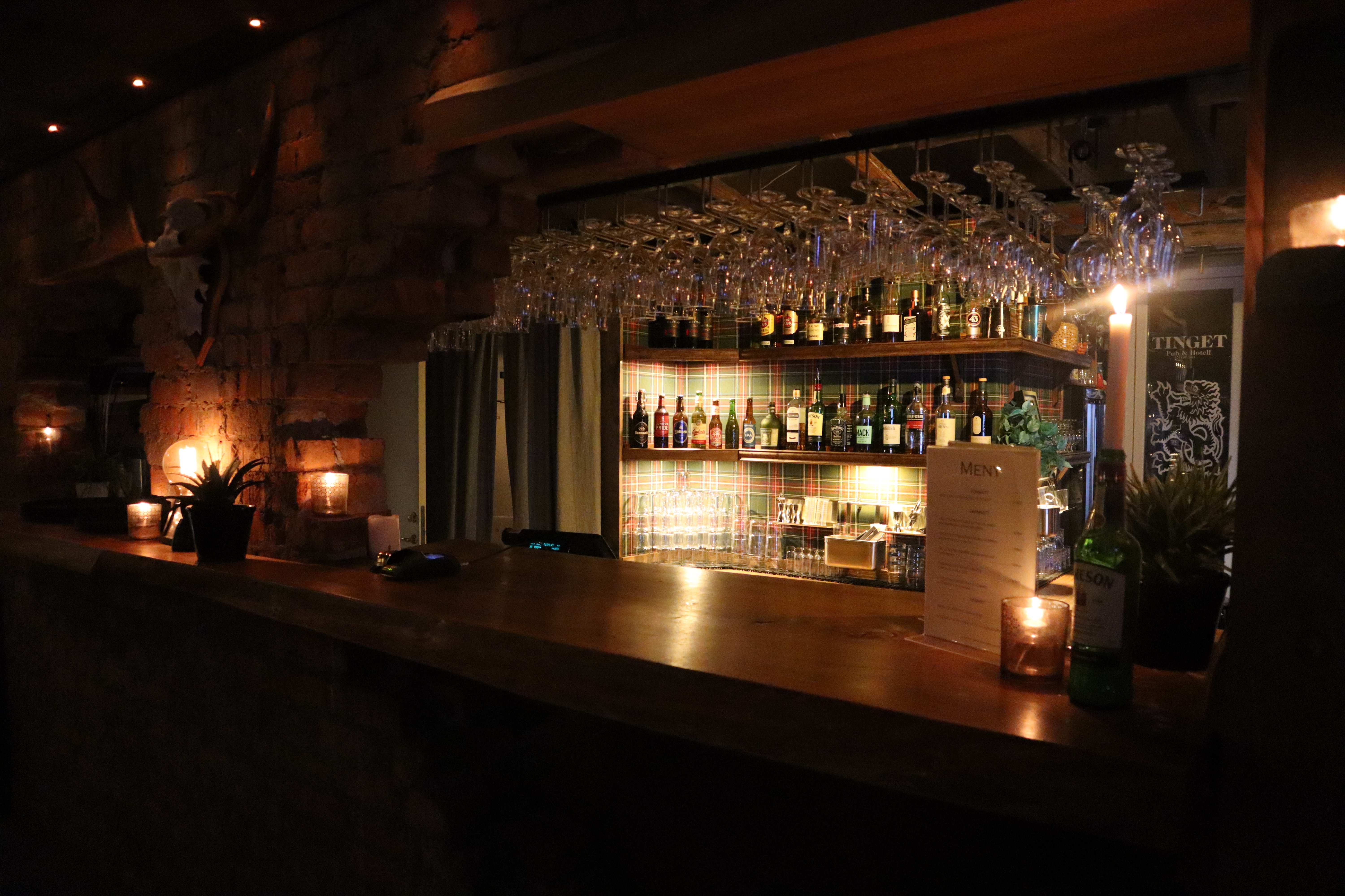 Elegant bar med omfattande glasvaror och flaskdisplay